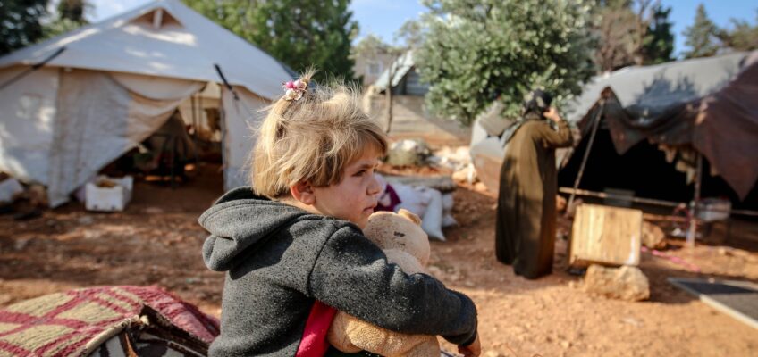cute girl with toy in refugee camp