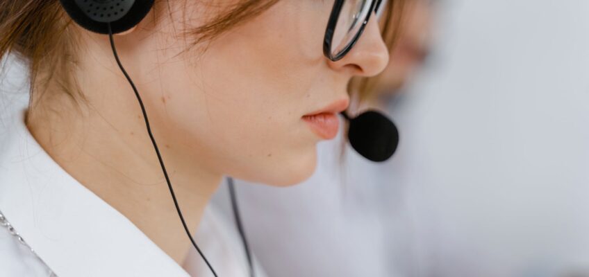 woman wearing eyeglasses with black headset and mouthpiece