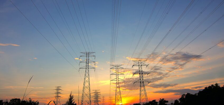 three black metal electricity posts during golden hour