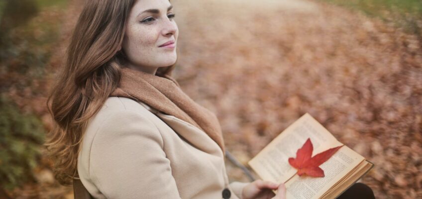 young woman with book in autumn park